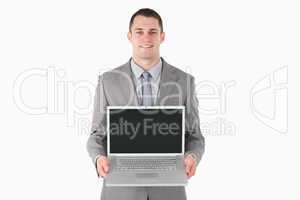 Smiling businessman showing a laptop