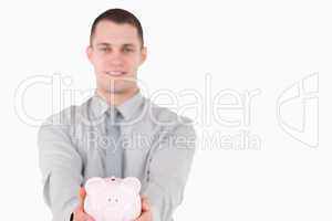 Young businessman holding a piggy bank