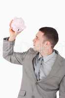 Portrait of a businessman looking in a piggy bank