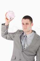 Portrait of a businessman shaking an empty piggy bank