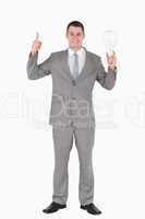 Portrait of a businessman holding a bulb and pointing at somethi
