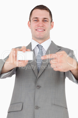 Portrait of a businessman pointing at a blank business card