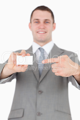 Portrait of a young businessman pointing at a blank business car