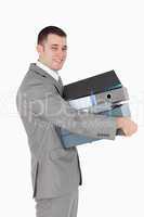 Portrait of a young businessman holding a stack of binders