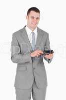 Portrait of a smiling businessman working with a calculator