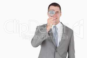 Businessman looking through a magnifying glass