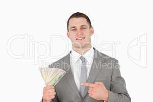 Businessman pointing at a wad of cash