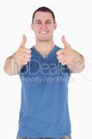 Portrait of a young man with the thumbs up