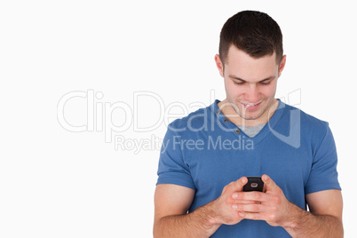 Smiling man sending text messages