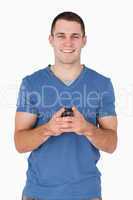 Portrait of a smiling man holding his mobile phone