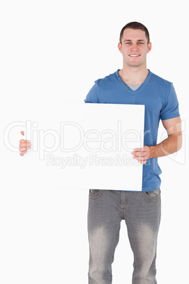 Portrait of a young man holding a blank panel