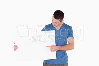 Young man pointing at a blank panel