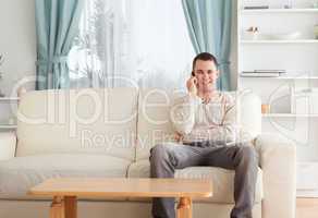 Man on the phone while sitting on his couch