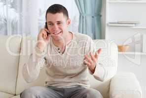Man talking through the phone while sitting on a couch