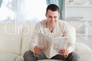 Happy man reading a newspaper