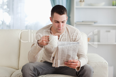 Man reading the news while drinking a coffee