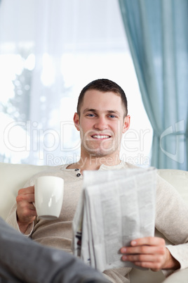 Portrait of a man having a tea while reading the news