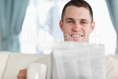 Handsome man having a coffee while reading the news