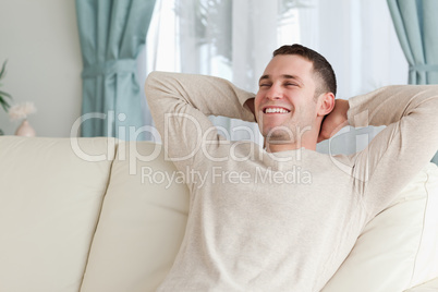 Laughing man relaxing on a sofa