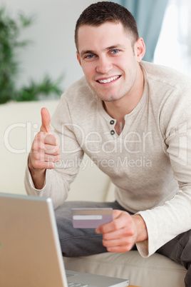 Portrait of a man purchasing online with the thumb up