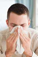 Portrait of a young man blowing his nose