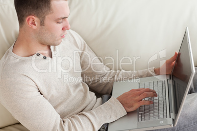 Good looking man relaxing with a laptop