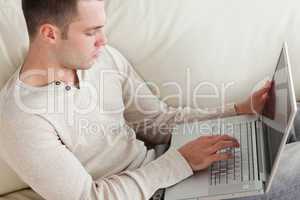 Good looking man relaxing with a laptop