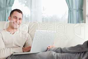 Smiling man relaxing with a notebook