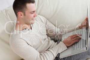 Happy man relaxing with a notebook