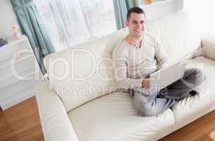 Handsome man relaxing with a notebook