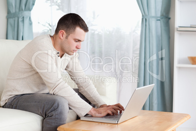 Young man typing on his laptop