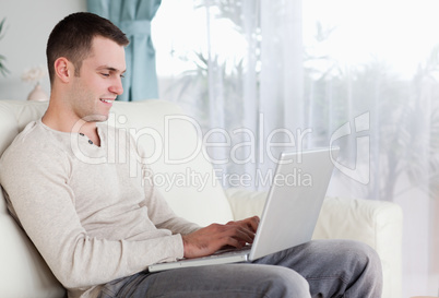 Happy man typing on his laptop