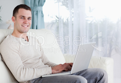Happy man typing on his notebook