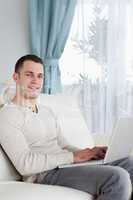 Portrait of a happy man typing on his notebook