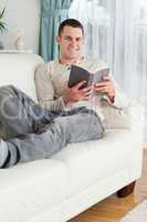 Smiling man relaxing with a book