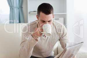 Young man reading the news while having a coffee