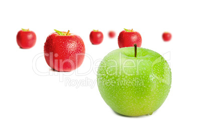 Green apple in front of red apples