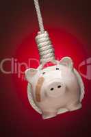 Piggy Bank with Bandage Hanging in Hangman's Noose on Red