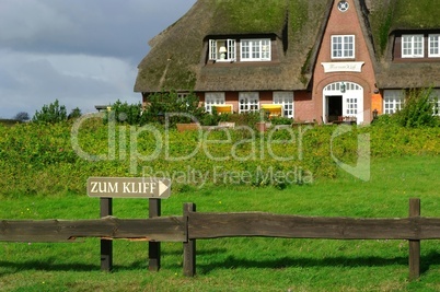Schild zum Kliff in Morsum auf Sylt mit Reetdachhaus