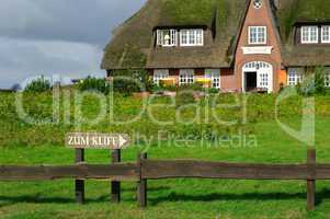 Schild zum Kliff in Morsum auf Sylt mit Reetdachhaus