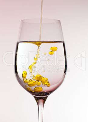 Olive oil being poured into wine glass