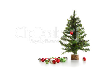 Small artifical tree with ornaments on white