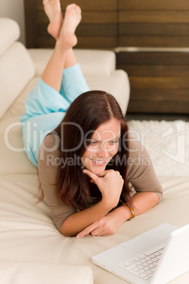 Modern living room woman lying sofa laptop