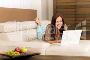 Modern living room woman lying sofa laptop