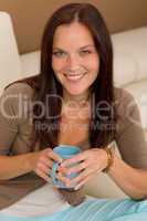Attractive woman sitting on modern home sofa