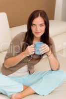 Attractive woman sitting on modern home sofa