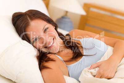 Bedroom smiling woman portrait in white bed