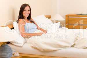 Beautiful woman working on computer in bed