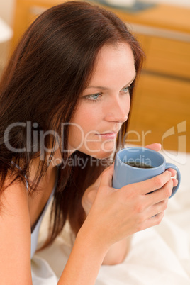 Bedroom - young woman drink coffee in bed