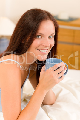 Bedroom - young woman drink coffee in bed